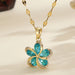Vue d'ensemble de trois Colliers Pendentifs Floraux Maison Mercier, ornés de zircons blancs, verts et rouges, en acier doré.