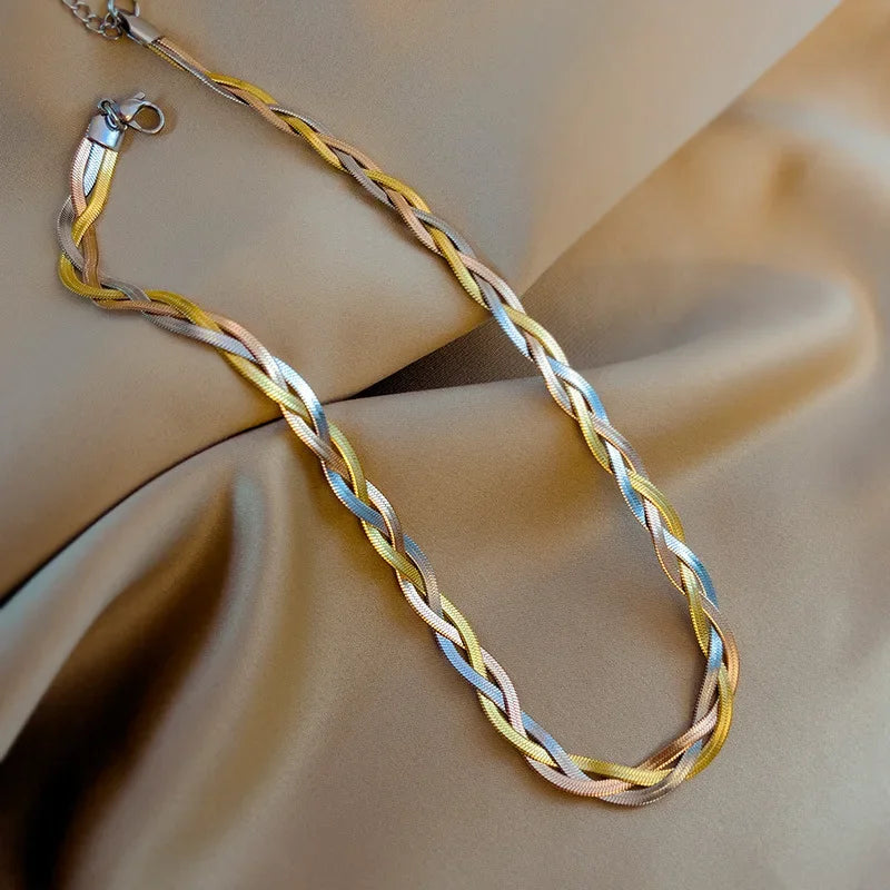 Détail d'une parure collier et bracelet tressés en maille serpent, présentant trois patines distinctes (or, argent, or rose), Maison Mercier.