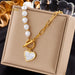 Détail d'un collier pendentif cœur 'Love' en acier inoxydable doré poli, posé sur un tissu élégant, Maison Mercier.