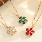 Vue d'ensemble de trois Colliers Pendentifs Floraux Maison Mercier, ornés de zircons blancs, verts et rouges, en acier doré.