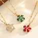 Vue d'ensemble de trois Colliers Pendentifs Floraux Maison Mercier, ornés de zircons blancs, verts et rouges, en acier doré.