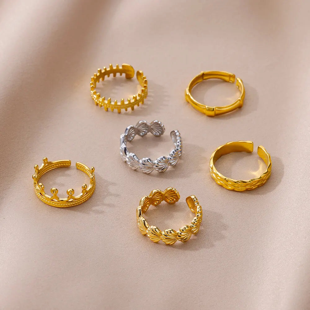 Détail d'une bague ajustable dorée en acier inoxydable, ornée d'un motif délicat de coquillages, Maison Mercier.