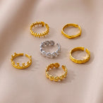 Détail d'une bague ajustable dorée en acier inoxydable, ornée d'un motif délicat de coquillages, Maison Mercier.