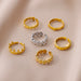 Détail d'une bague ajustable dorée en acier inoxydable, ornée d'un motif délicat de coquillages, Maison Mercier.