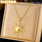 Détail d'un collier pendentif soleil rayonnant en acier inoxydable doré, présenté sur un écrin beige, Maison Mercier.