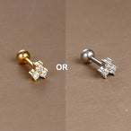Piercing d'oreille fleur à cinq pétales en zircons, en acier chirurgical doré, présenté dans un écrin beige raffiné, Maison Mercier.