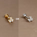 Piercing d'oreille fleur à cinq pétales en zircons, en acier chirurgical doré, présenté dans un écrin beige raffiné, Maison Mercier.