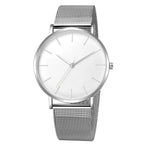Montre féminine Maison Mercier, cadran noir épuré, bracelet maille milanaise finition or rose, portée au poignet avec un bracelet délicat à perles dorées.