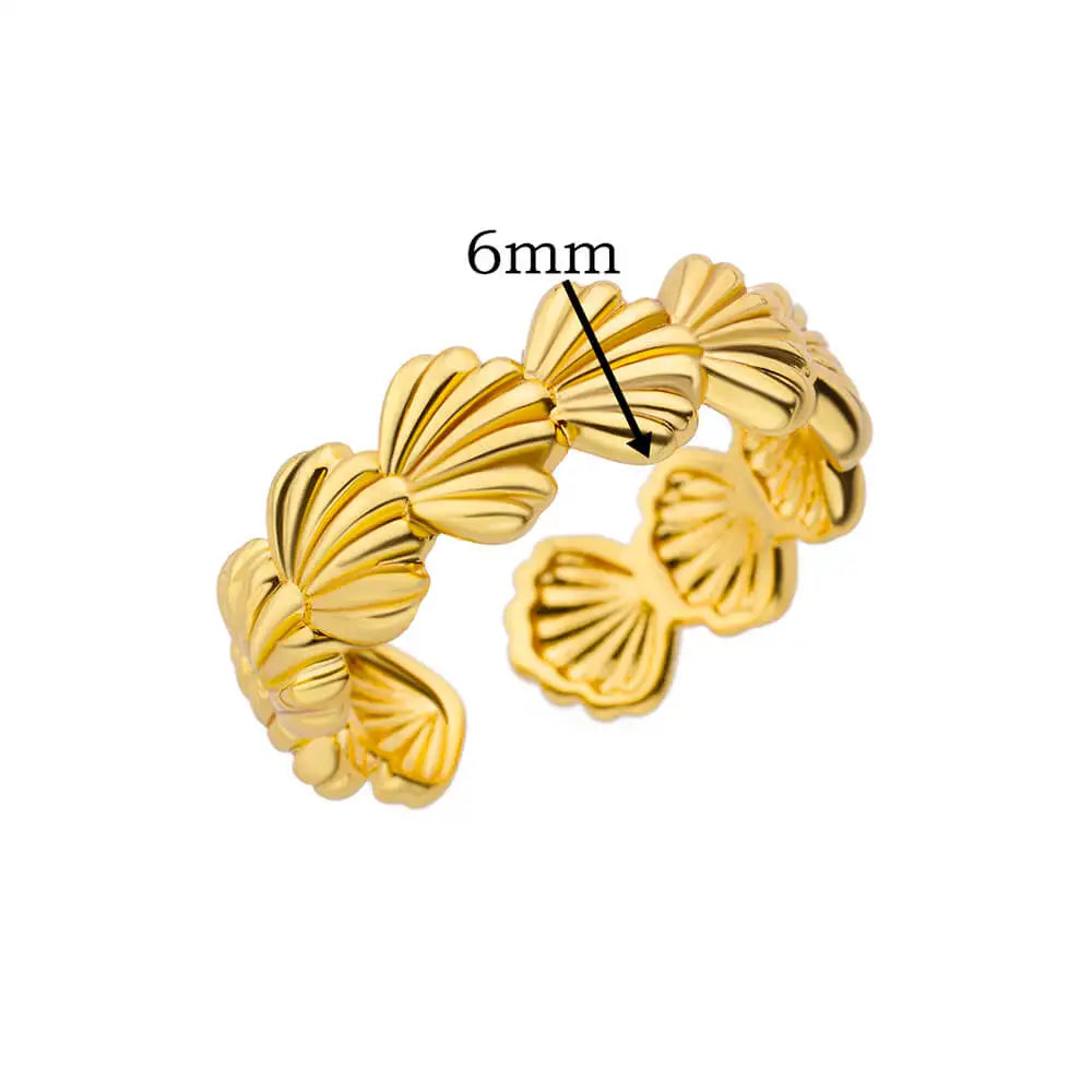 Détail d'une bague ajustable dorée en acier inoxydable, ornée d'un motif délicat de coquillages, Maison Mercier.