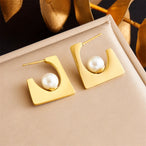 Paire de boucles d'oreilles puces sphériques polies en acier inoxydable doré, Maison Mercier.