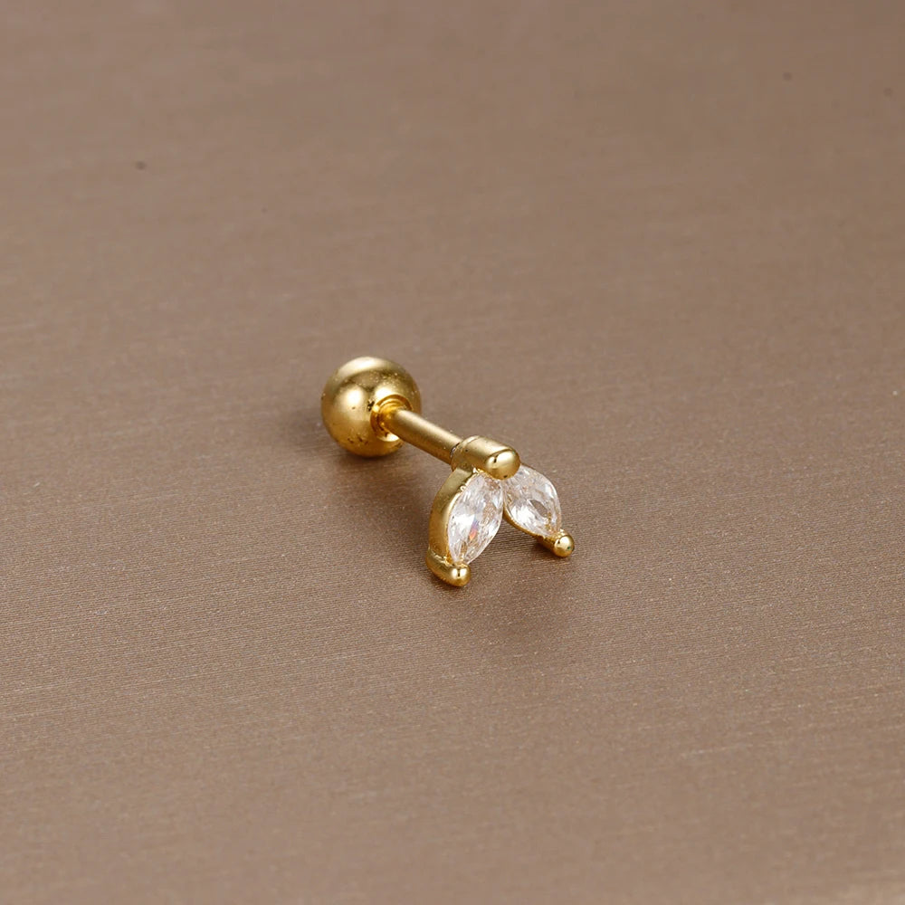 Détail d'un piercing d'oreille anneau ouvert orné de zircons, en acier chirurgical doré, Maison Mercier.