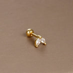 Détail d'un piercing d'oreille anneau ouvert orné de zircons, en acier chirurgical doré, Maison Mercier.