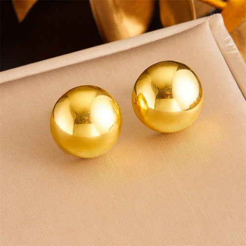 Détail d'une collection de boucles d'oreilles variées en acier inoxydable doré, présentant des designs géométriques, perlés et organiques, Maison Mercier.