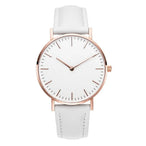 Montre féminine Maison Mercier, cadran noir épuré, bracelet maille milanaise finition or rose, portée au poignet avec un bracelet délicat à perles dorées.