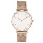 Montre féminine Maison Mercier, cadran noir épuré, bracelet maille milanaise finition or rose, portée au poignet avec un bracelet délicat à perles dorées.