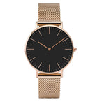 Montre féminine Maison Mercier, cadran noir épuré, bracelet maille milanaise finition or rose, portée au poignet avec un bracelet délicat à perles dorées.