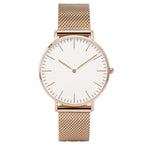 Montre féminine Maison Mercier, cadran noir épuré, bracelet maille milanaise finition or rose, portée au poignet avec un bracelet délicat à perles dorées.