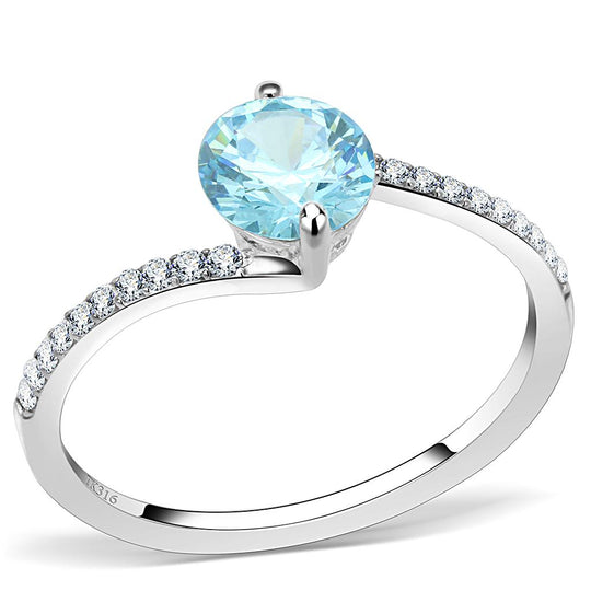 Détail d'une bague bypass en acier chirurgical 316L poli, sertie d'un zirconium bleu ciel rond et d'un pavé de cristaux, Maison Mercier.
