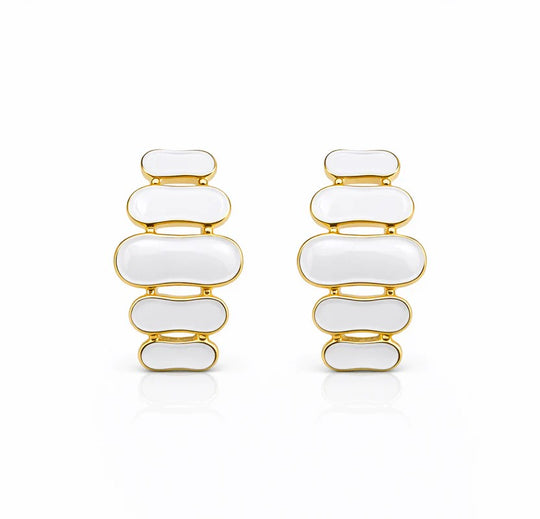 Paire de boucles d'oreilles pendantes à maillons oblongs émaillés blanc pur, finition or précieux, sur fond blanc immaculé, Maison Mercier.