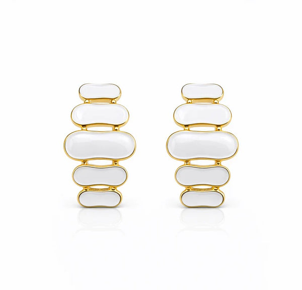 Paire de boucles d'oreilles pendantes à maillons oblongs émaillés blanc pur, finition or précieux, sur fond blanc immaculé, Maison Mercier.