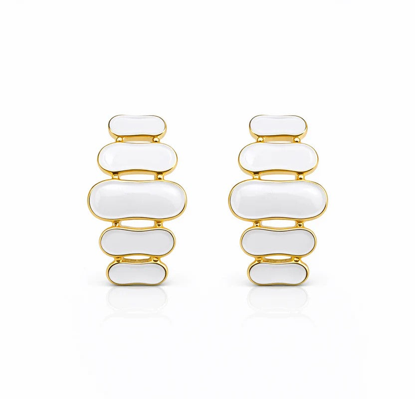 Paire de boucles d'oreilles pendantes à maillons oblongs émaillés blanc pur, finition or précieux, sur fond blanc immaculé, Maison Mercier.