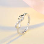 Détail d'une bague infini ajustable en finition argentée, ornée d'oxydes de zirconium scintillants, Maison Mercier.