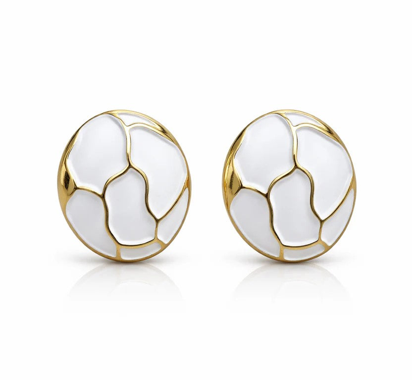 Vue de face d'une paire de boucles d'oreilles puces rondes en émail blanc et motifs dorés, isolées sur un fond blanc avec une légère réflexion, Maison Mercier.