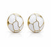 Vue de face d'une paire de boucles d'oreilles puces rondes en émail blanc et motifs dorés, isolées sur un fond blanc avec une légère réflexion, Maison Mercier.