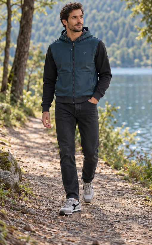 Un homme adulte portant Sweat Lyle & Scott bleu homme, Jean Replay Grover homme, Baskets Diadora Rally Waxed homme. Au bord du lac. Mise en scène IA illustrative.